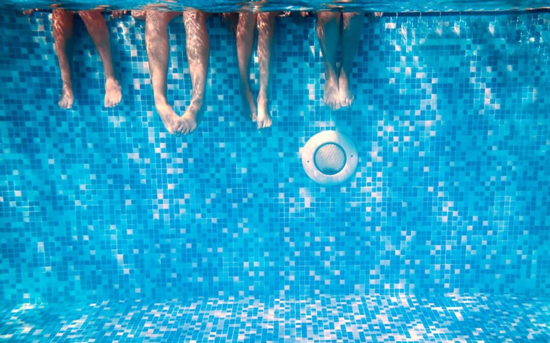 Pieds dans l'eau au dessus d'un spot d'une piscine carrelée