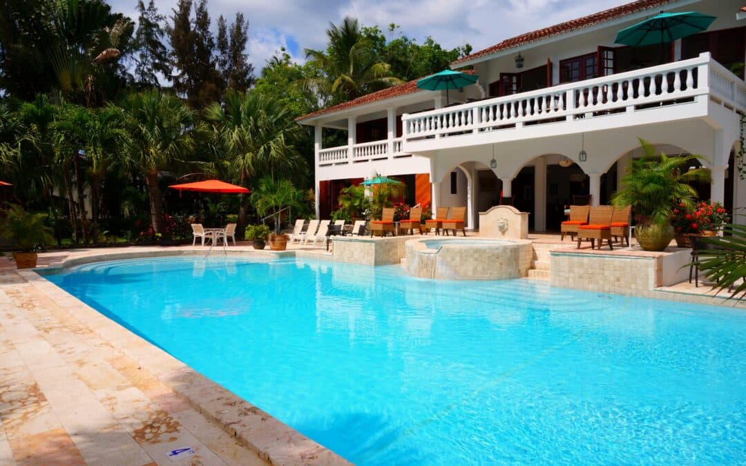 Grande piscine avec jacuzzi devant une maison blanche