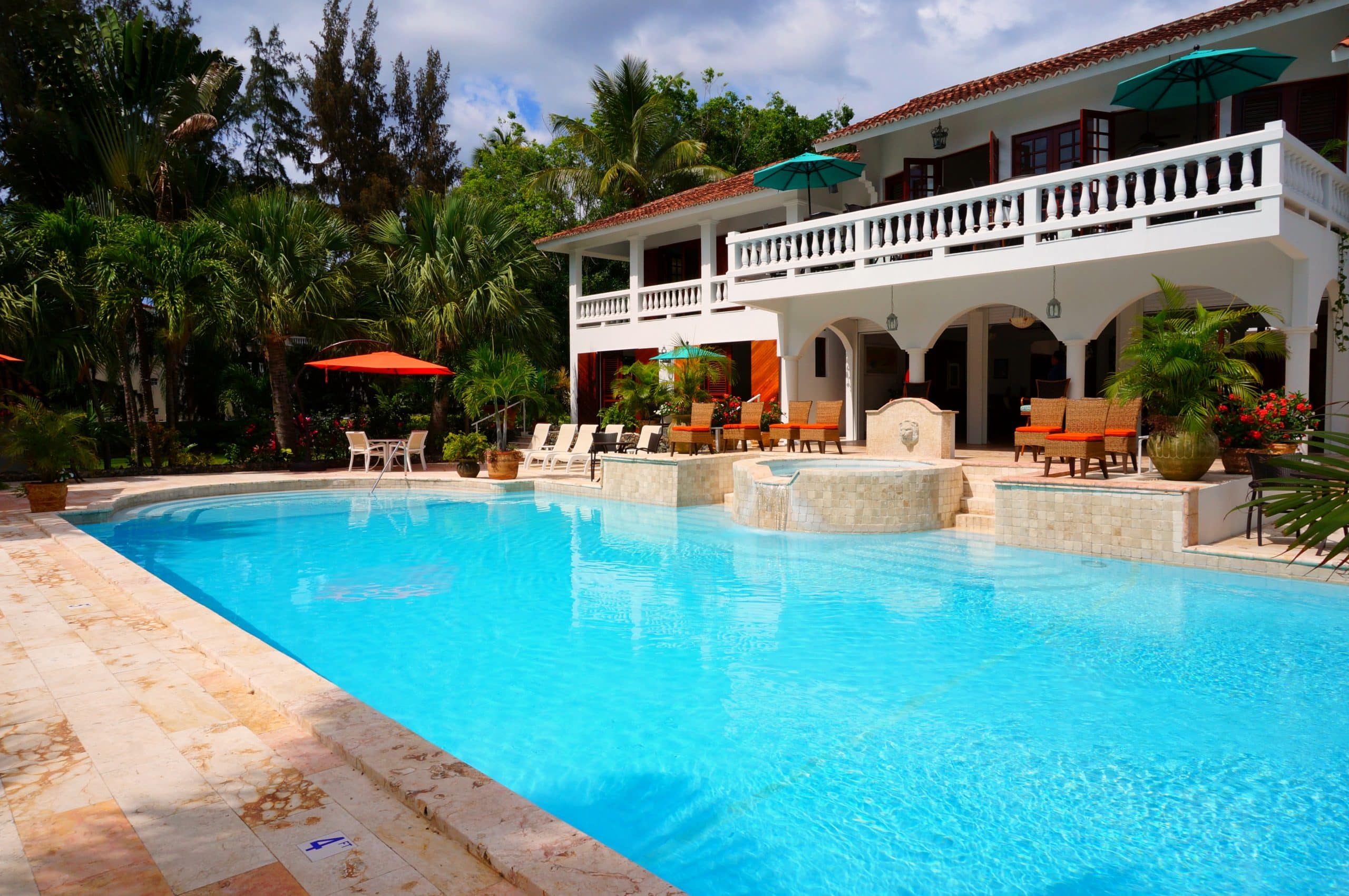 Grande piscine avec jacuzzi devant une maison blanche