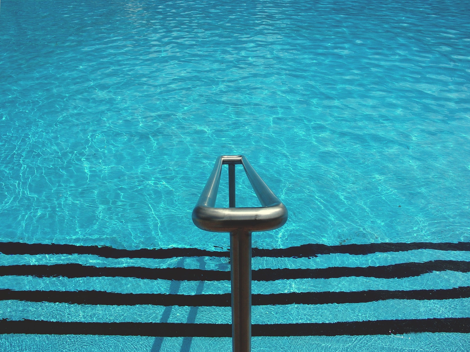 Marches et rampe descendant dans l'eau claire d'une piscine