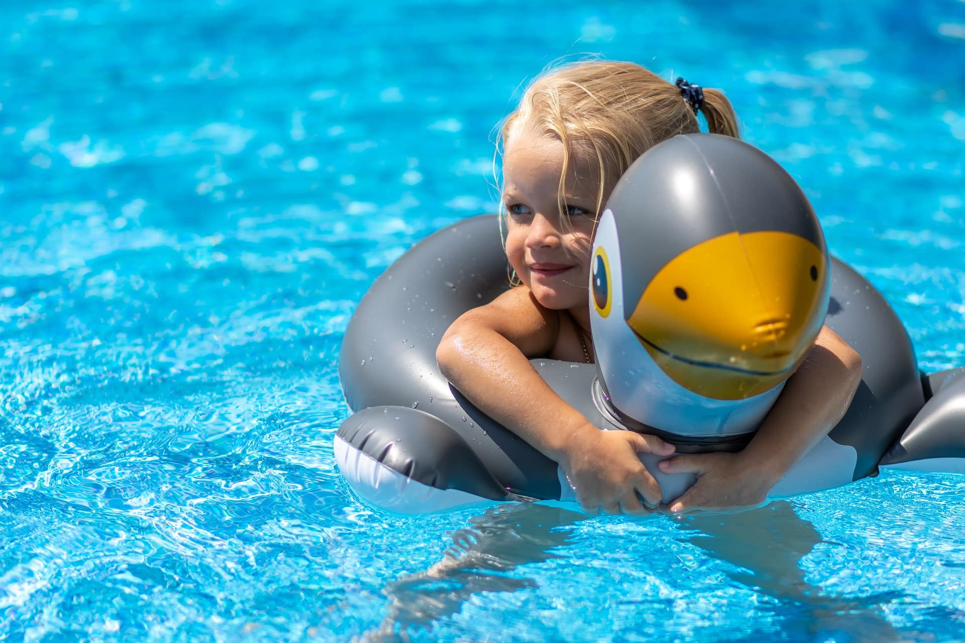 Petite fille avec bouée canard dans une piscine