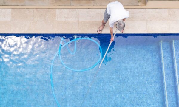 Vue de haut d'un homme nettoyant sa piscine
