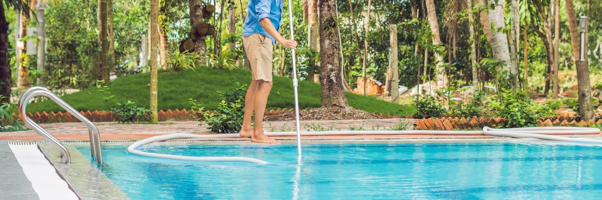 Homme passant le balais aspirant dans sa piscine