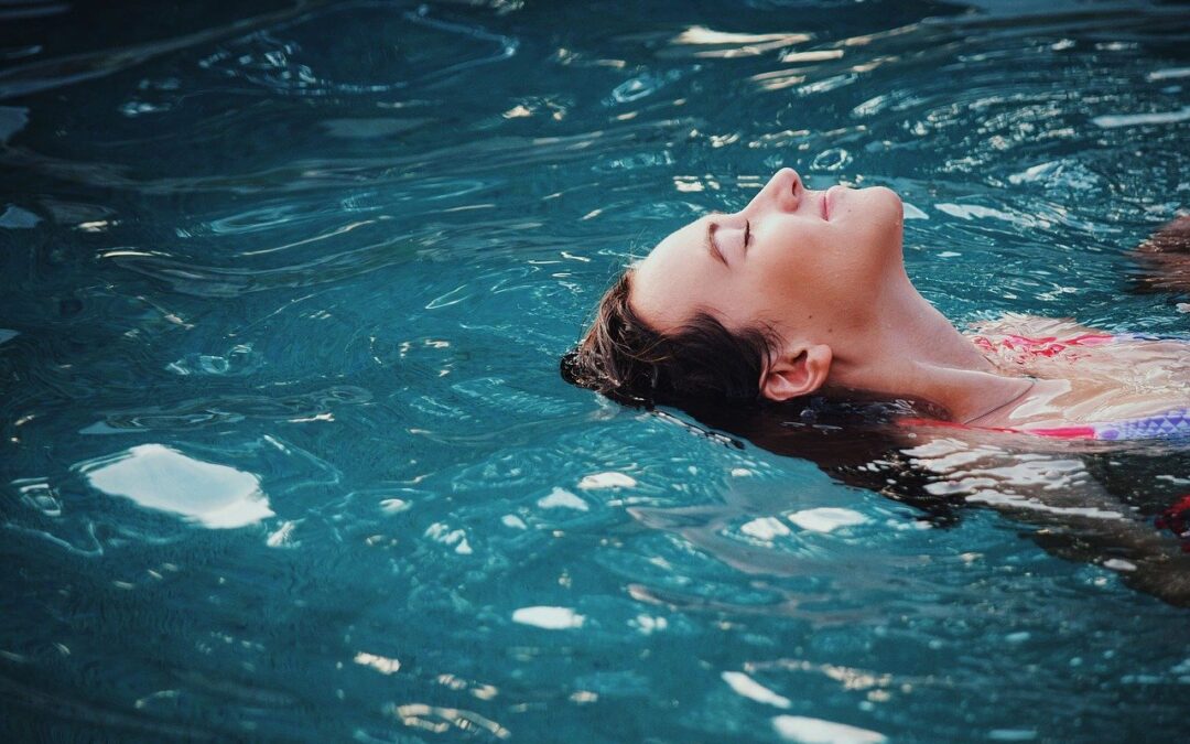 Femme nageant sur le dos et la tête dans l'eau