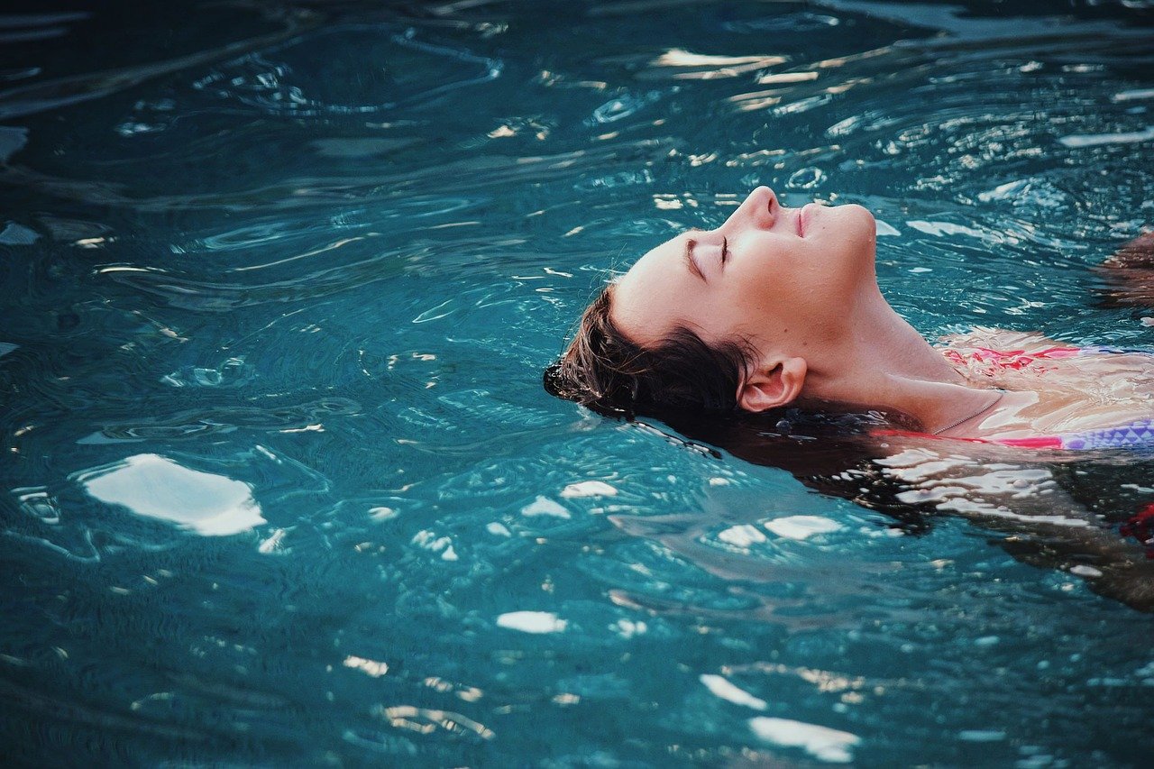 Femme nageant sur le dos et la tête dans l'eau