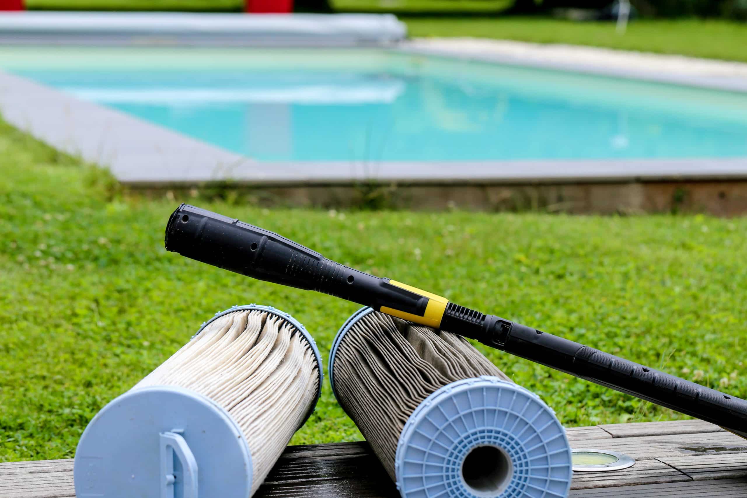 Cartouches de filtre et lance de Karcher devant piscine