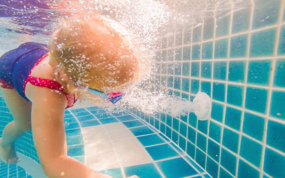 Enfant dans l'eau devant les bulles d'un refoulement