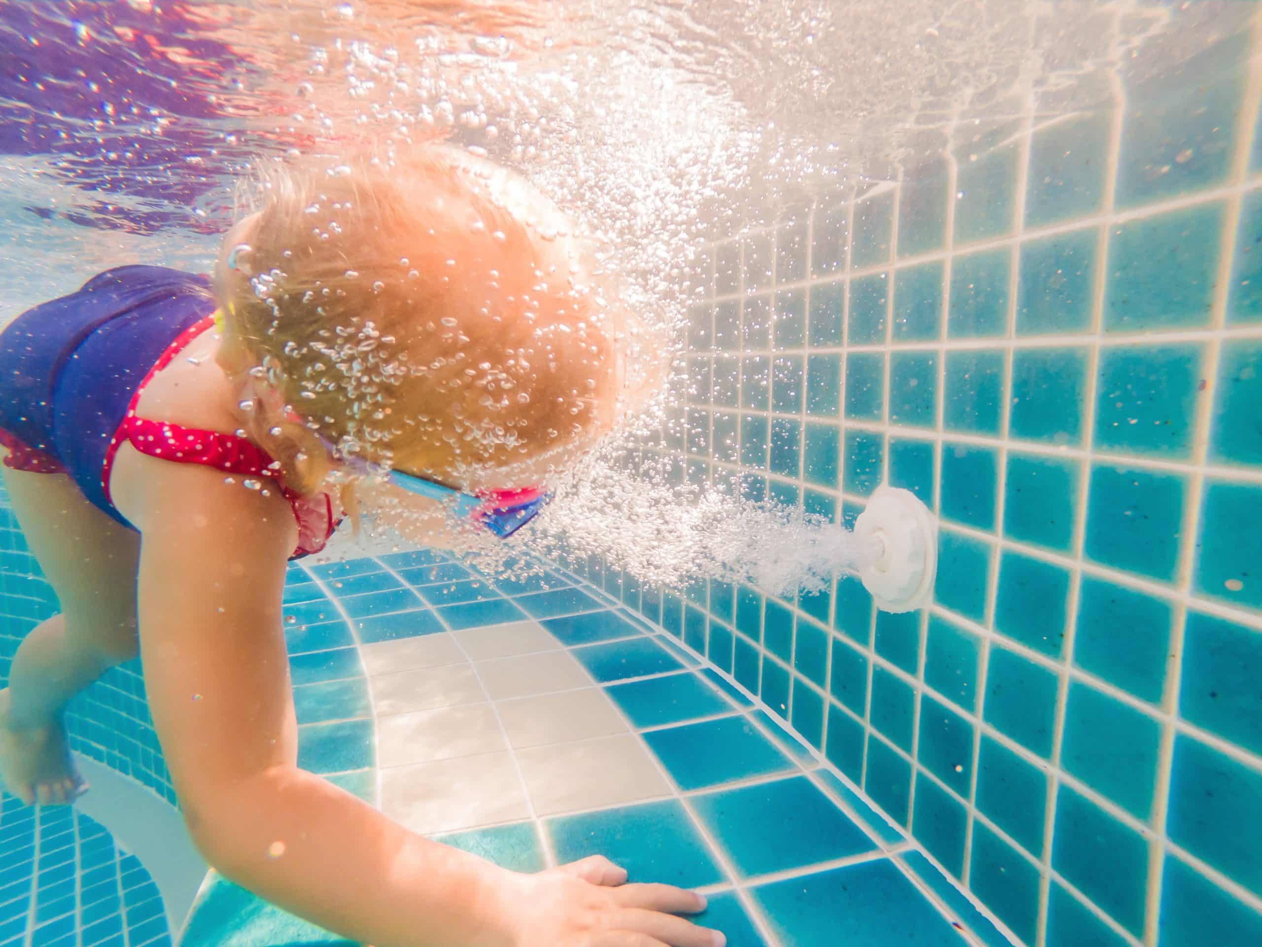 Enfant dans l'eau devant les bulles d'un refoulement