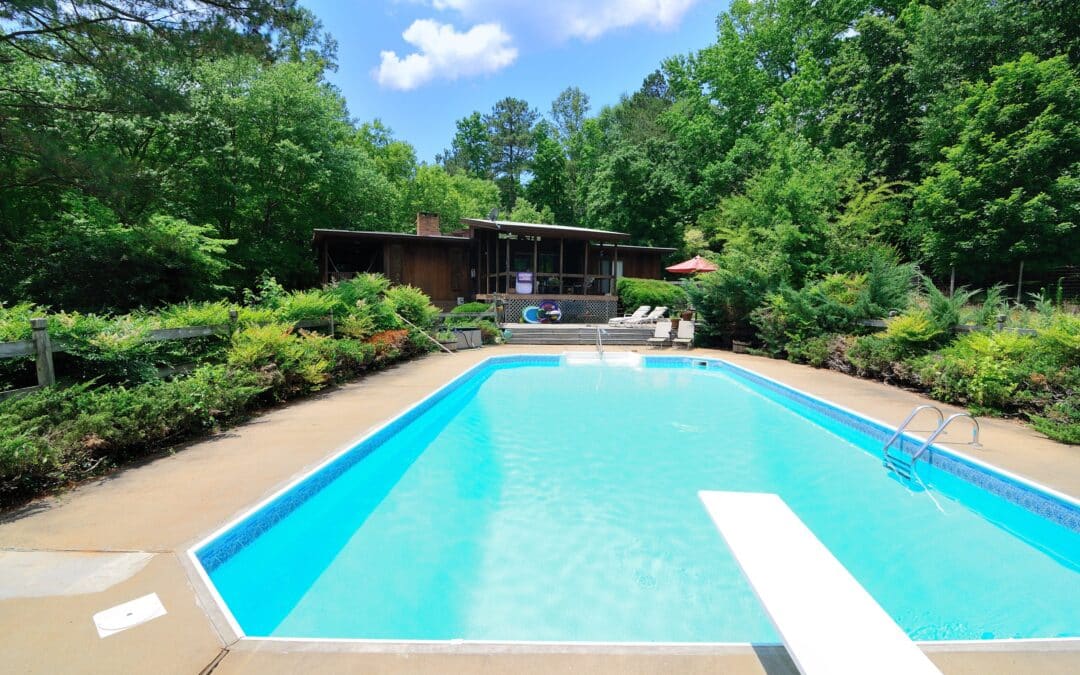 Piscine devant maison entourée de végétation